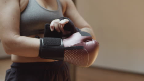 Close-up-shot-of-womans-hands-putting-on-boxing-gloves